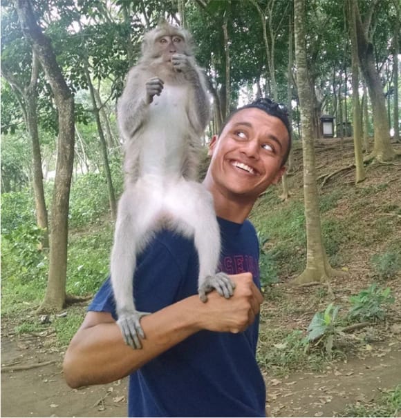 Amar with a monkey on his shoulder while traveling